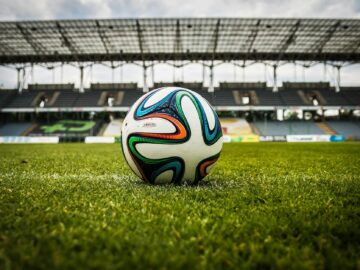 multicolored soccer ball on green field